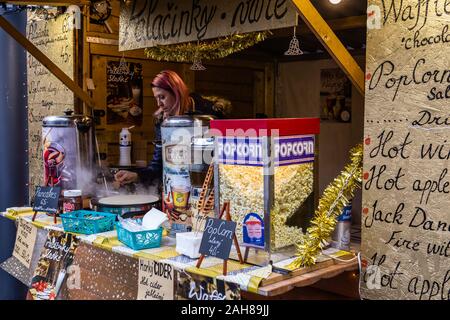 Praga, Repubblica Ceca, Dicembre 12, 2019: Femmina la preparazione di pancake e altri cibi da strada al mercatino di Natale nel centro di Praga Foto Stock