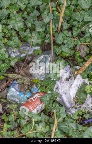 Pila di uso singola in plastica imballaggi alimentari littering un angolo di campagna. Molti marchi in modo RM solo editoriale. Campagna inquinata UK. Foto Stock