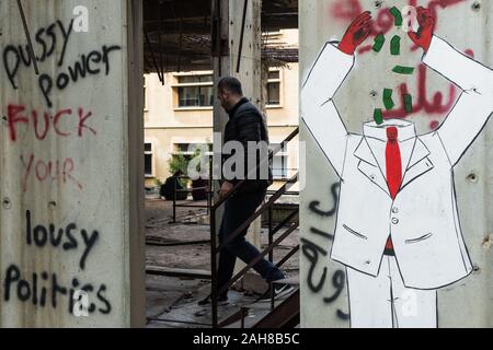 Uomo che cammina giù per le scale a "L'Uovo' edificio abbandonato a Beirut il distretto centrale durante il 2019 proteste, Beirut, Libano Foto Stock