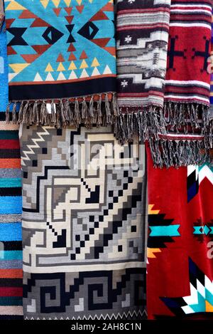 Coperte con Native American designs appendere su una cremagliera al di fuori di un negozio di souvenir a Santa Fe, New Mexico. Foto Stock