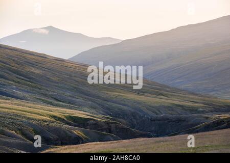 Ampia vista panoramica di un iconico paesaggio islandese con un certo numero di colline inclinate che si intersecano l'una con l'altra Foto Stock