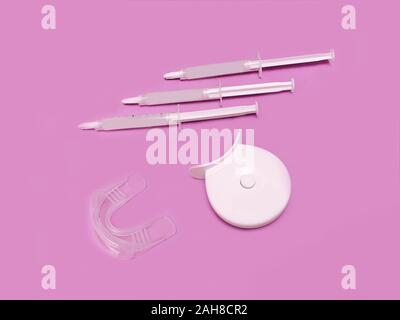 Set di sbianca con scatola isolata su sfondo rosa. Home gel sbiancante opalescenza del vassoio. Kit alla moda per cure dentarie. Medicina, dente attrezzature di bellezza Foto Stock