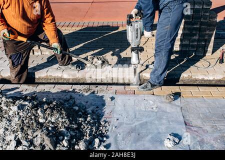 I lavoratori di cui pavimentazione in lastre. Due lavoratori laici di lastre per pavimentazione. Foto Stock