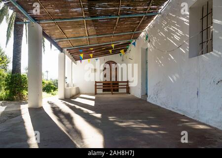 Ingresso della Chiesa abadoned Ermita de Sant Antoni y Sant Jaume nel cappuccio Blanche con drammatica raggi solari, Altea, Spagna Foto Stock