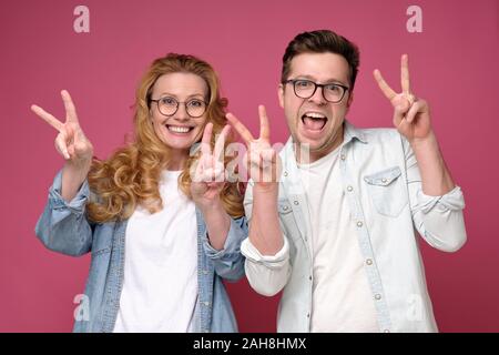 Matura coppia caucasici che mostra due dita e prendendo un selfie Foto Stock