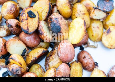 Grigliare piccole patate con fettine di aglio su una piscina grill a gas. Foto Stock