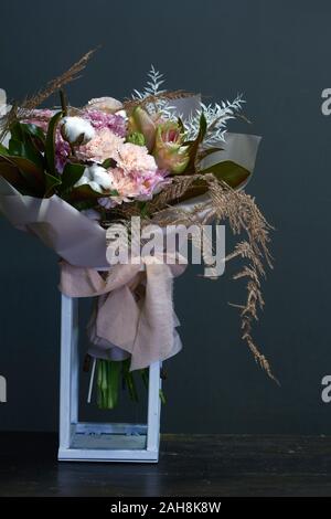 Bouquet originale in stile vintage su una superficie di legno in un geometrico di un supporto in metallo, saluto in background o di concetto Foto Stock