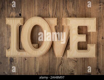 Lettere di legno costituente la parola amore su di un legno di noce sfondo. Concetto di giorno di San Valentino Foto Stock