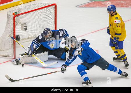 Trinec, Repubblica Ceca. Il 26 dicembre, 2019. L-R Portiere Justus Annunen e Mikko Kokkonen (entrambi FIN) e Nils Hoglander (SWE) in azione durante il 2020 IIHF mondo junior di Hockey su ghiaccio campionati del Gruppo una corrispondenza tra la Svezia e la Finlandia in Trinec, nella Repubblica ceca il 26 dicembre 2019. Credito: Vladimir Prycek/CTK foto/Alamy Live News Foto Stock