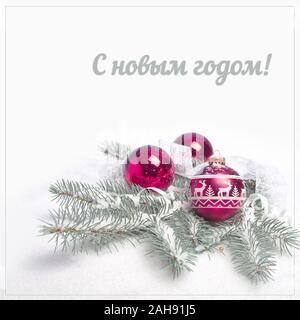 Felice Anno Nuovo testo in lingua russa. Tre baubles magenta in abete rami sotto la neve, square composizione isolata su sfondo bianco con testo spac Foto Stock