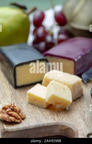 Mini nero e rosso scuro cerata formaggi cheddar realizzato da ovest paese latte e secolare e metodi in Inghilterra da vicino Foto Stock