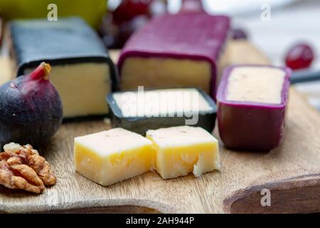 Mini nero e rosso scuro cerata formaggi cheddar realizzato da ovest paese latte e secolare e metodi in Inghilterra da vicino Foto Stock