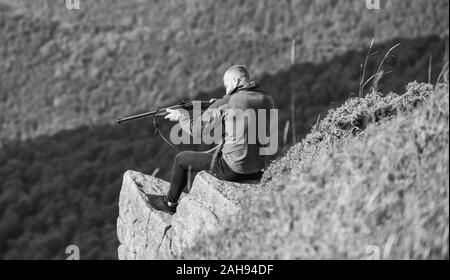 Stile militare. maschio nel camuffamento. muscolare di man tenere arma. Scopo e successo. forze armate. sniper raggiungere la montagna bersaglio. soldato nel campo. poligono. l uomo pronto a far fuoco. hunter hobby. Foto Stock