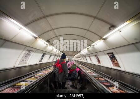 PRAGUE, Repubblica Ceca - 2 Novembre 2019: persone, una famiglia, scendendo una scala mobile con una velocità di movimento di sfocatura, correndo per raggiungere la piattaforma di un metro st Foto Stock