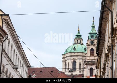 La Chiesa di San Nicola, chiamato anche Kostel Svateho Mikulase, a Praga Repubblica Ceca, con la sua cupola iconica visto da vicino le strade con il barocco tipico Foto Stock