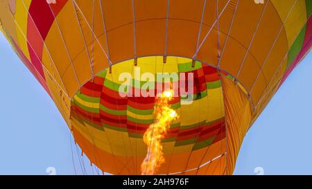 Una vista ravvicinata di una fiamma riscaldamento dell'aria all'interno di una colorata mongolfiera, per i turisti in Kenya. Foto Stock