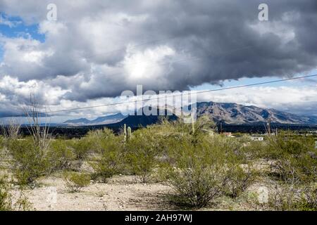 Magnifica vista tempesta oscurato lontano Santa Catalina montagne come nuvole passare rapidamente in cielo visto dal sole alto deserto nella periferia occidentale di Tucson Foto Stock