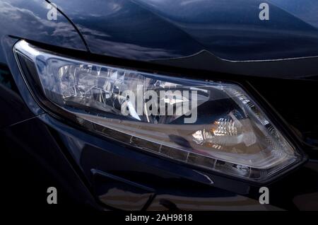 Faro auto close-up. Auto faro anteriore per la guida nel buio. Foto Stock
