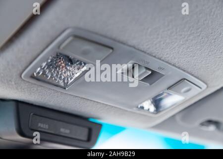 Comando di illuminazione all'interno della vettura dalla parte superiore del quadro della strumentazione dietro il retrovisore in bianco con pulsanti Foto Stock