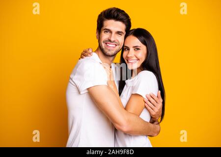 Foto di incredibile coppia in amore azienda ogni altro in mani non hai visto per anni casual wear white t-shirts isolato di colore giallo, sfondo Foto Stock