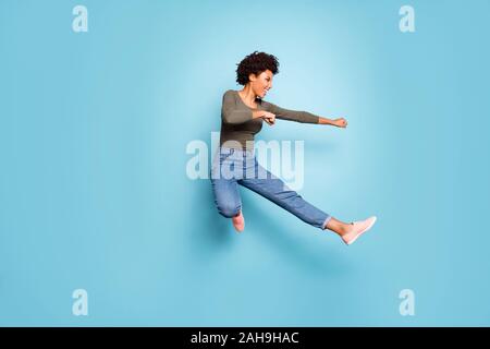 Lunghezza completa foto di pelle scura ondulata lady jumping alta danza moderna giovane si sposta a praticare Judo lotta indossare abbigliamento casual isolato pastello blu Foto Stock