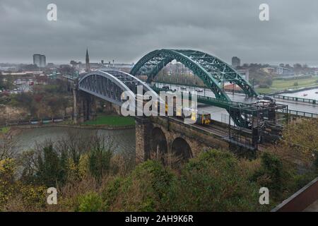 Nexus Tyne and Wear metro attraversando il ponte di Monkwearmouth, Sunderland (fiume) di usura su uno scialbo, wet giornata invernale Foto Stock