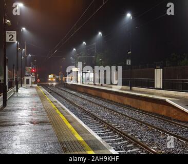 Nexus Tyne and Wear Metro treno arrivando alla banca stazione piede su una buia notte umido Foto Stock