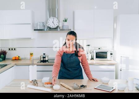 Giovane donna la preparazione di biscotti di Natale a casa. Fatte a mano Gingerbread cookie. Foto Stock