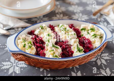 Le aringhe salate in una salsa cremosa con pera, patate, cipolle, barbabietole e mirtilli rossi. Foto Stock