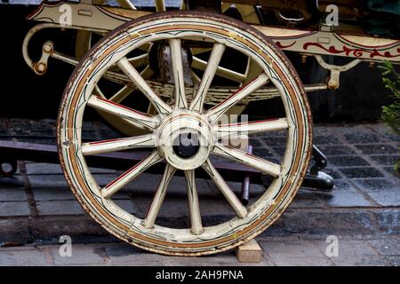 Il vecchio di legno verniciato gypsy caravan ruota ad una fiera di paese Foto Stock