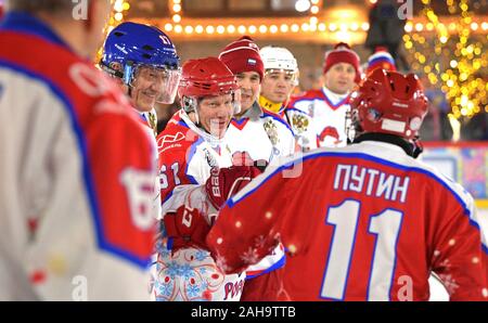 Il presidente russo Vladimir Putin, #11, saluta i giocatori durante un amichevole hockey su ghiaccio corrispondono nella notte Hockey League a grandi magazzini GUM pattinaggio su ghiaccio in Piazza Rossa Dicembre 25, 2019 a Mosca, in Russia. Foto Stock