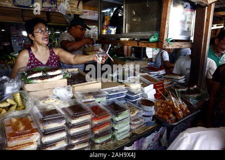 Antipolo City, Filippine - 23 dicembre 2019: fornitori ad un pubblico mercato umido vendono snack assortiti articoli ai clienti. Foto Stock