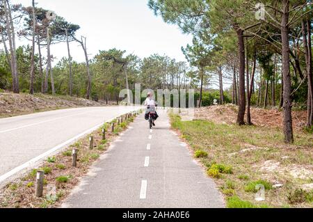 Cicli di donna sulla Eurovelo 1 costa atlantica rotta vicino a Nazar nel Portogallo centrale. Questo percorso ciclabile corre lungo l'oceano Atlantico Foto Stock