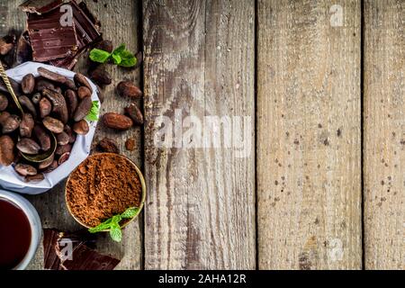 Differenti condizioni di cacao. Vari prodotti di cacao - fave, fagioli, massa, frantumato di cacao in polvere, pasta cioccolato, pezzetti di cioccolato e cioccolata calda in una cu Foto Stock