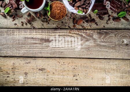 Differenti condizioni di cacao. Vari prodotti di cacao - fave, fagioli, massa, frantumato di cacao in polvere, pasta cioccolato, pezzetti di cioccolato e cioccolata calda in una cu Foto Stock