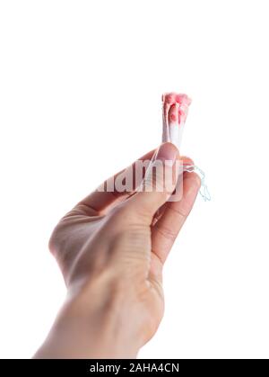 Donna che mantiene un medici usati tamponi su uno sfondo bianco. Le mestruazioni, mezzi di protezione. Simulazione delle mestruazioni Foto Stock