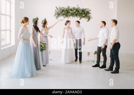 Gli ospiti gettando coriandoli sopra la sposa e lo Sposo ad un matrimonio. Foto Stock