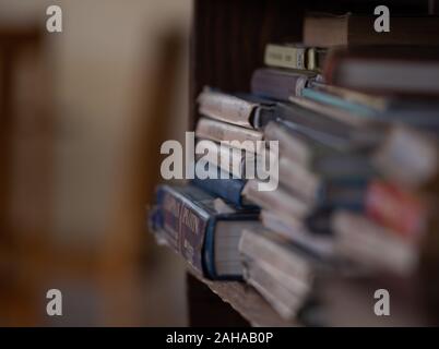 Pile di libri su uno scaffale di legno. Foto Stock