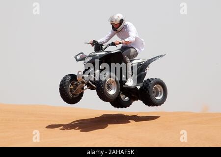 30.03.2018, Dubai, Dubai, Emirati Arabi Uniti - adolescente comanda un quad bike attraverso il deserto. 00S180330D055CAROEX.JPG [modello di rilascio: sì, proprietà Foto Stock