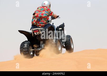 30.03.2018, Dubai, Dubai, Emirati Arabi Uniti - adolescente comanda un quad bike attraverso il deserto. 00S180330D057CAROEX.JPG [modello di rilascio: sì, proprietà Foto Stock