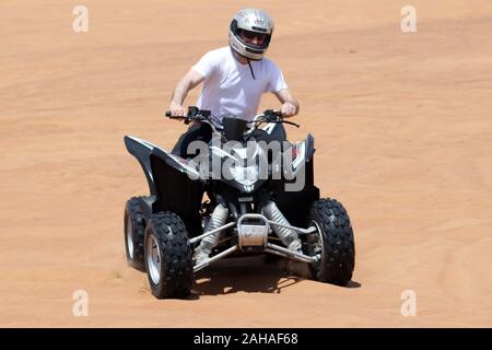 30.03.2018, Dubai, Dubai, Emirati Arabi Uniti - Uomo aziona un quad bike attraverso il deserto. 00S180330D062CAROEX.JPG [modello di rilascio: sì, proprietà rele Foto Stock