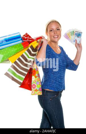 Eine junge Frau kommt mit vielen Einkaufstaschen vom Shopping zurück. In der ein mano Bündel Euro Geldscheine, signor: Sì Foto Stock