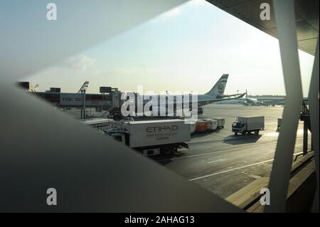 04.01.2014, ad Abu Dhabi , Emirati Arabi Uniti - Vista attraverso una finestra nella sala partenze del piazzale dell'aeroporto internazionale. 0SL140104D008 Foto Stock