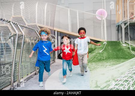 Allegro carino bimbi piccoli tenendo da mani mentre lungo il parco giochi Foto Stock