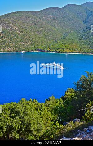 Una vista in alzata della spiaggia Antisamos e bay, una delle più belle in vacanza isola di Kefalonia. Un lussuoso yacht a motore ormeggiata al largo. Foto Stock