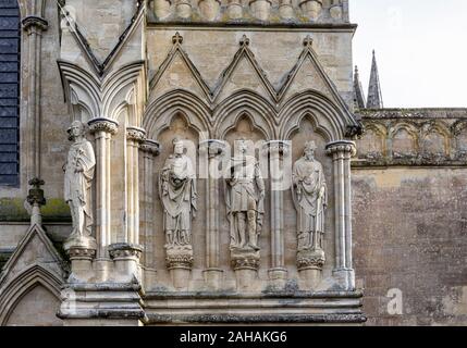 Statue in pietra di St Alban, St Alphege, St Edmund martire & San Tommaso di Canterbury sull'esterno fronte ovest della cattedrale di Salisbury, Wiltshire, Regno Unito Foto Stock