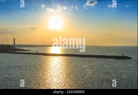 Porto di Bari al tramonto: Il molo e il faro. Tramonto sul mare: Costa della Puglia. Foto Stock