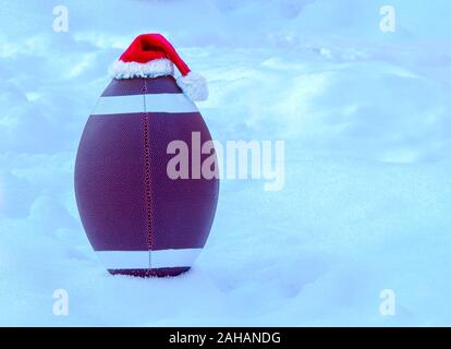 American Football indossa un Berretto di Babbo Natale sulla neve Foto Stock