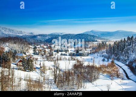 Inverno in Croazia, paesaggio di campagna in inverno, vista panoramica della cittadina di Lokve sotto la neve nella regione di Gorski kotar Foto Stock