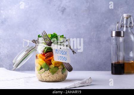 Insalata di fatti in casa in un barattolo di vetro con la quinoa e verdure con etichetta ora di pranzo no plastica e prendere distanza concetto Foto Stock